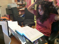 Girl sitting at computer pulling her hair with look of frustration.